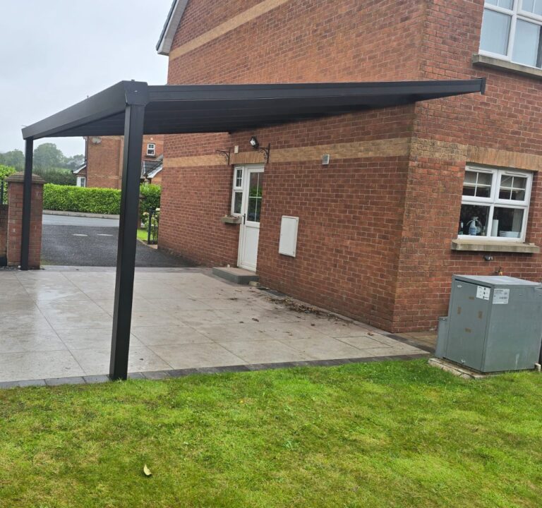 Grey carport fixed to a brick house