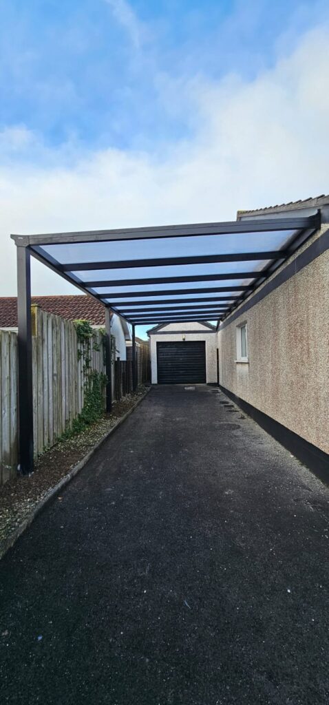Long grey aluminium carport down the side of a house