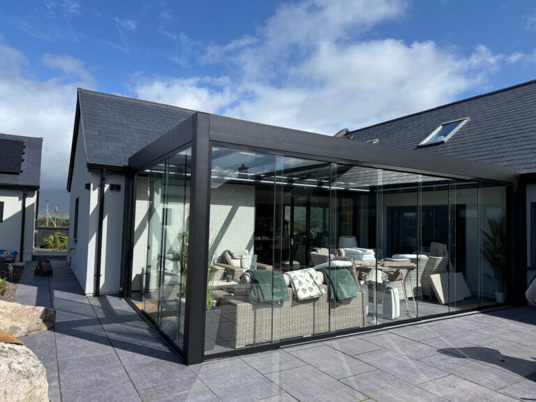 Glass room with frameless sliding glass doors fitted by Apex Verandas in Cork